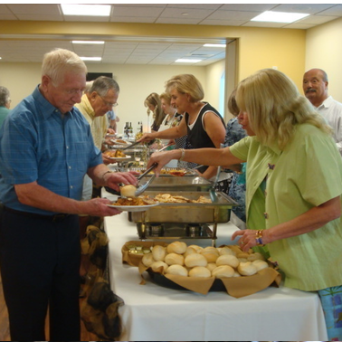 Volunteers serving food at a buffet