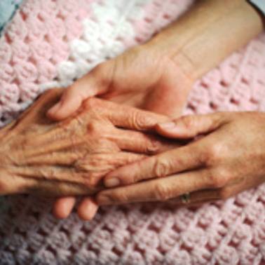 Hands resting on a pink knitted blanket