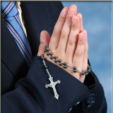 Hands folded in prayer holding a rosary