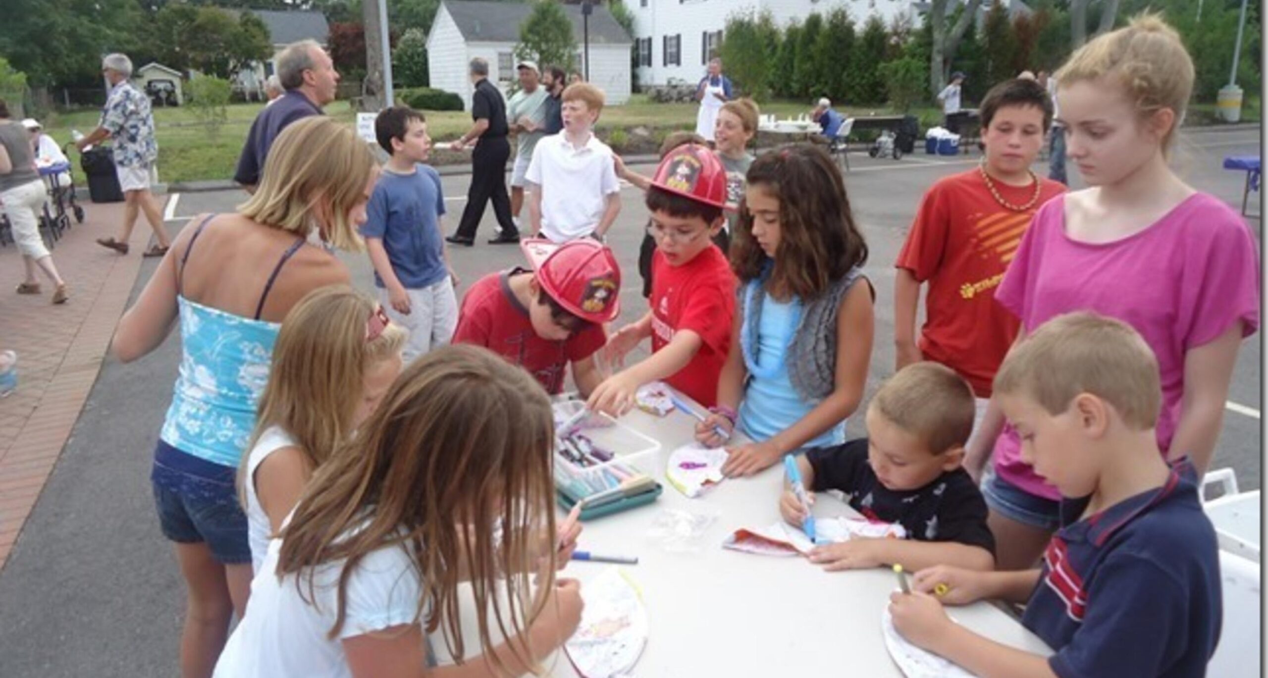 Children doing crafts at an outdoor table