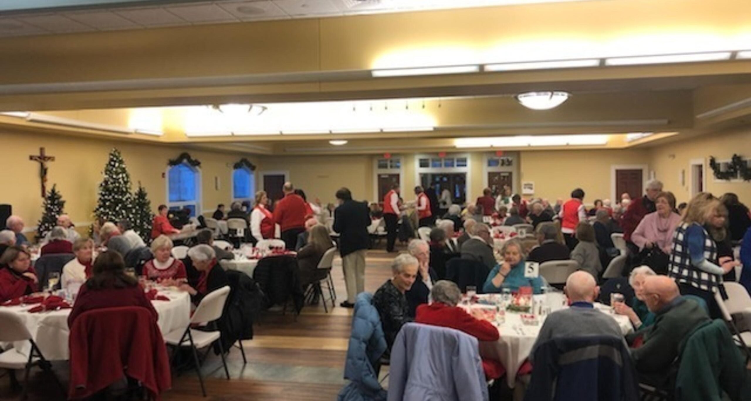 Parishioners seated at tables in the parish hall