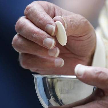 Hand holding a Communion host