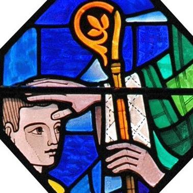 Stained glass of a figure beside a crosier